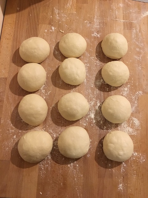 A 3x4 grid of soft butter rolls to be baked.